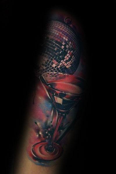 Vibrant martini glass tattoo with a disco ball, reflecting a party theme. A bold and dynamic design with rich colors and glowing effects.