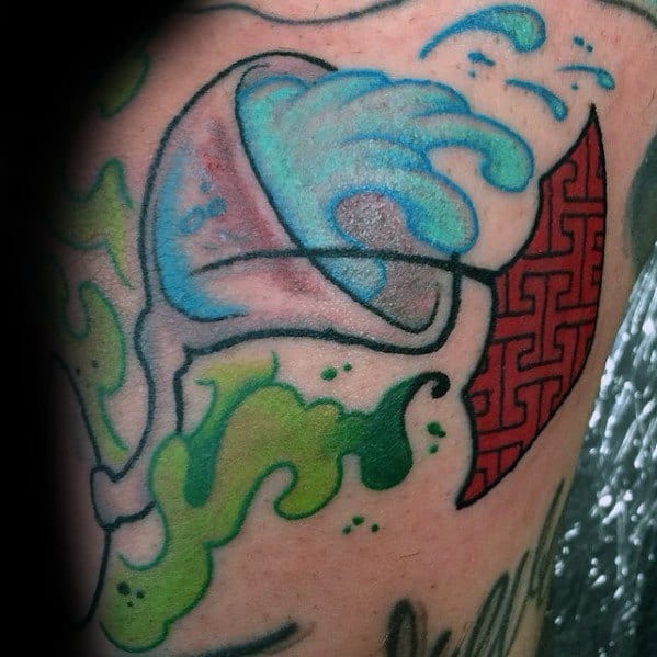 Colorful martini glass tattoo with a wave splash and abstract elements. A bold, dynamic design blending aquatic and artistic influences.