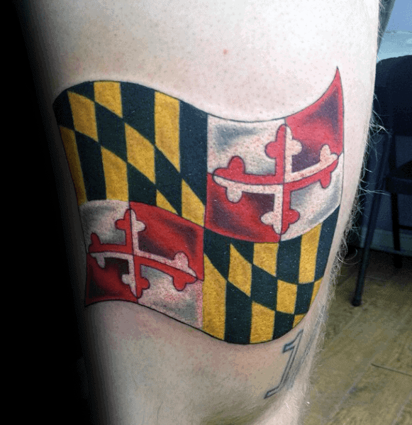 Maryland flag tattoo on the thigh with a waving effect, creating a realistic look with bold colors and crisp details.