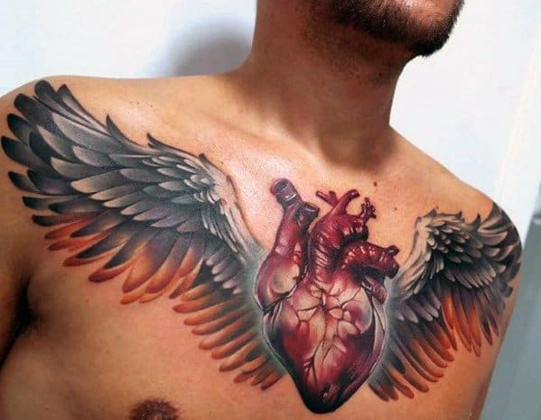Realistic 3D chest tattoo of an anatomical heart with large, detailed wings, symbolizing freedom, passion, and resilience.