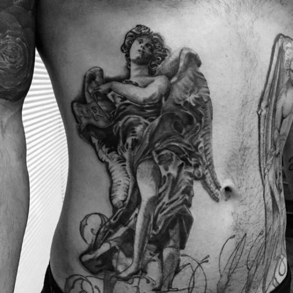 A detailed black and grey tattoo on the side, depicting an angel with large wings, holding a book, with intricate shading and flowing robes.