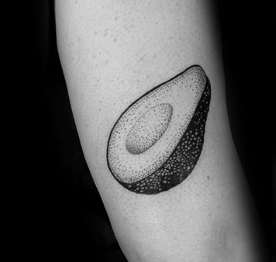 Blackwork avocado tattoo on the arm using dotwork shading and textured skin detail, giving it a clean yet artistic minimalist feel.