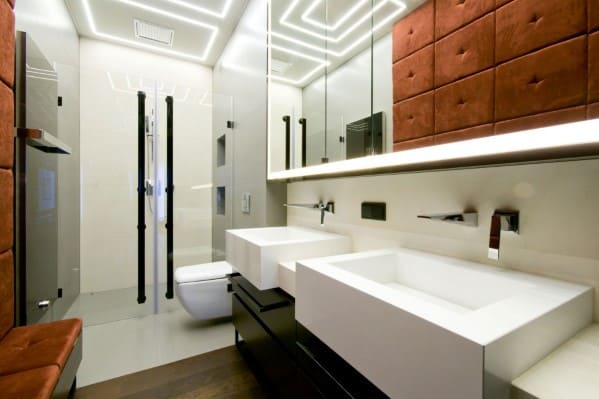 Modern bathroom with dual sinks, wall mirrors, glass shower, and sleek lighting