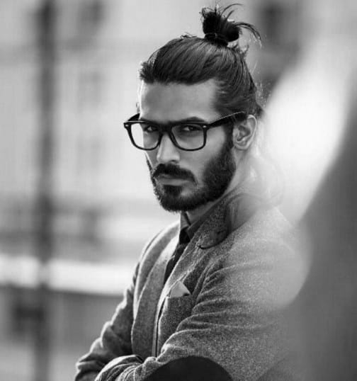 Man with long hair in a top knot and a full beard