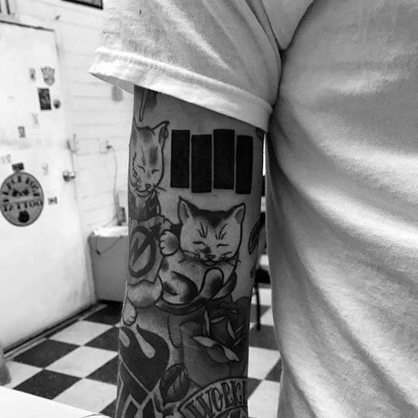 Black Flag bars tattooed on the upper forearm, placed above playful cat illustrations for a bold yet whimsical punk contrast.