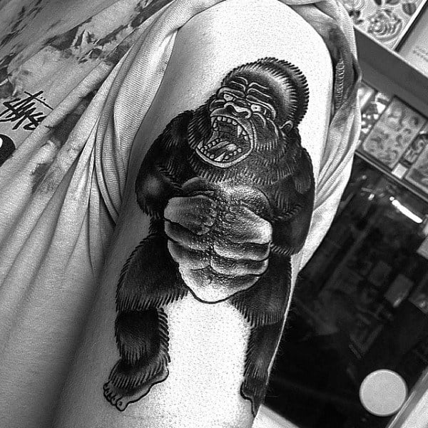 Masculine Black Gorilla Pounding Chest On Upper Arm Of Man