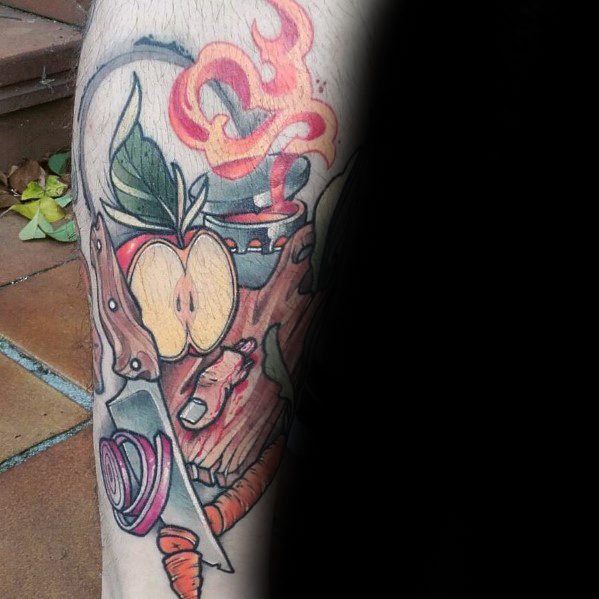 Vibrant food-themed tattoo featuring a sliced apple, onion, carrot, knife, and steaming pot, blending bold colors and dynamic composition.