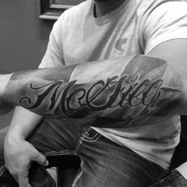 Forearm tattoo featuring bold script reading "McStill" over a shaded checkered flag background, symbolizing personal identity and racing passion.