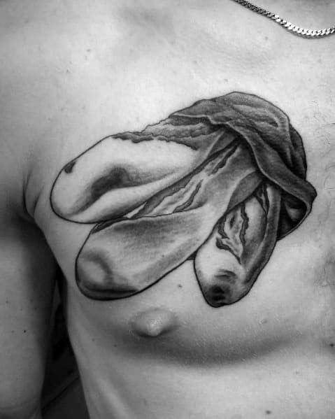Realistic black and gray tattoo of baguettes wrapped in cloth on the chest, featuring detailed shading for a bold and artistic bakery-inspired design.