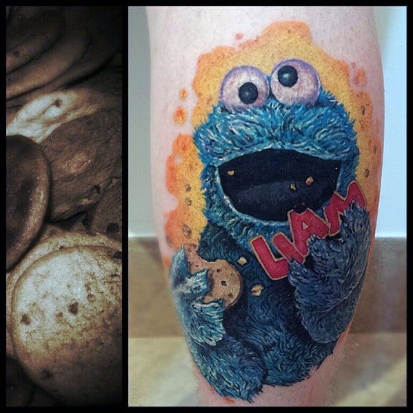 Bright Cookie Monster tattoo holding a cookie and red "LIAM" name tag, with orange splatter background and playful expression.