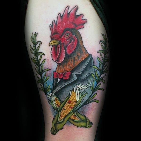 Colorful tattoo of a rooster in a tuxedo with corn cobs and laurel branches, blending farm and formal themes in a bold design.