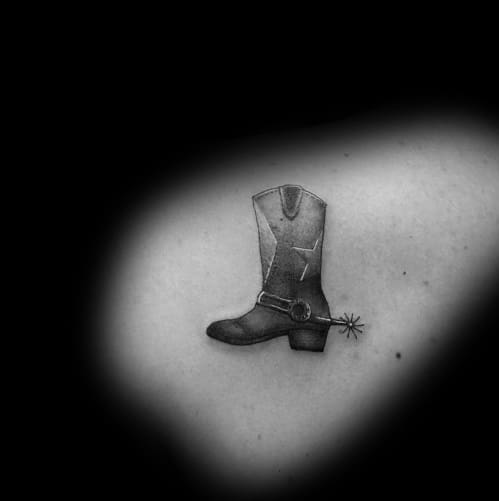 Minimalist black and white tattoo of a cowboy boot with a spur, symbolizing Western heritage, simplicity, and rugged independence.