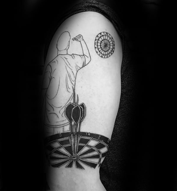 Upper arm tattoo of a darts player aiming at a dartboard, with bold darts embedded in a larger board below, capturing focus and dedication.