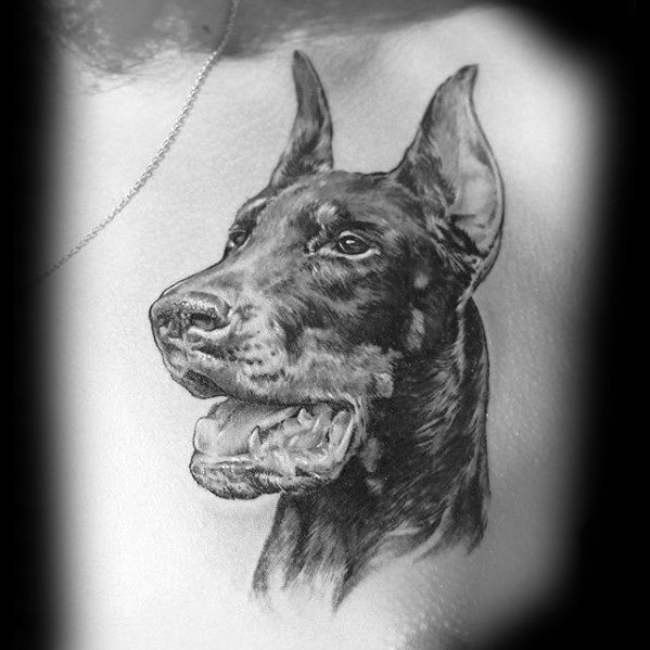 Realistic black and grey Doberman tattoo with detailed fur and expressive eyes, capturing a proud and alert posture.