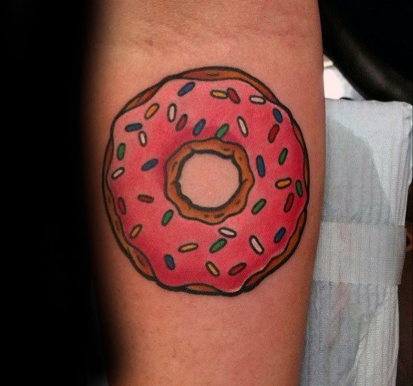 Tattoo of a classic pink frosted donut with colorful sprinkles, bold outlines, and a clean, cartoon-style finish.