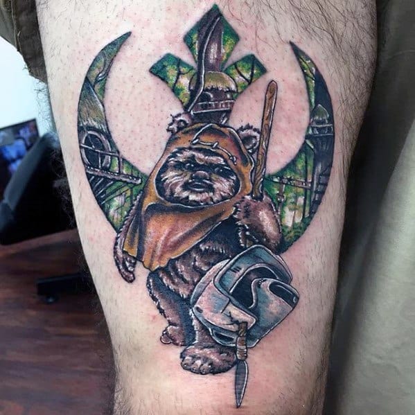 Ewok tattoo with a spear and a scout trooper helmet, set against the Rebel Alliance symbol filled with Endor’s forest and structures.