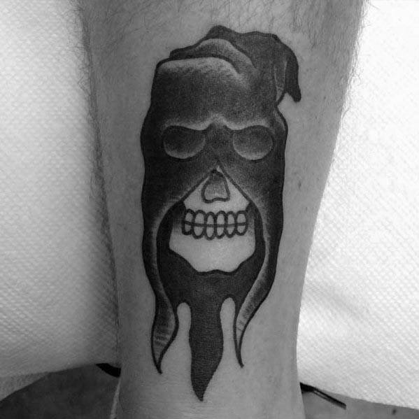 Dark executioner tattoo featuring a hooded skull with deep shading, blending the mask into the bone for a haunting, seamless design.