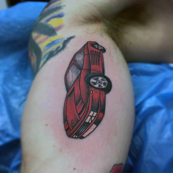 Simple red Ferrari Testarossa tattoo on man's inner arm, representing iconic automotive style and personal passion.