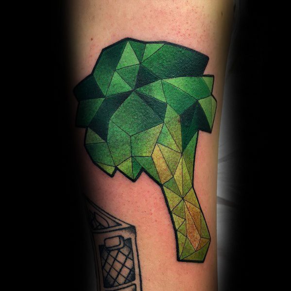 Geometric broccoli tattoo on the forearm, featuring sharp polygonal shapes and vibrant green shading for a bold and modern design.
