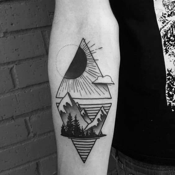 Geometric forearm tattoo of mountains, sun, clouds, and trees with layered triangle elements and dotted sun rays.