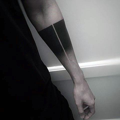 Minimalist forearm tattoo with a bold black rectangle fading into a smooth grey gradient and a sharp vertical line dividing the design.