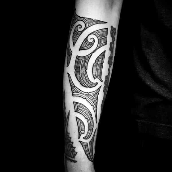 Forearm tattoo featuring intricate geometric and tribal patterns
