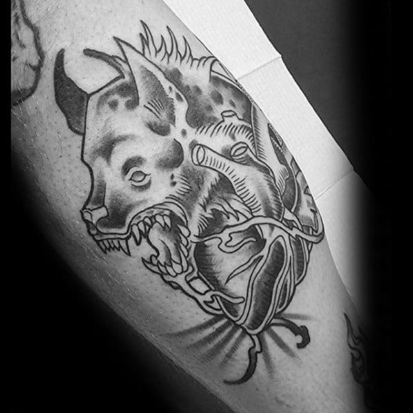 Black and grey tattoo of a snarling hyena fused with an anatomical heart, combining fierce expression with surreal, symbolic linework.