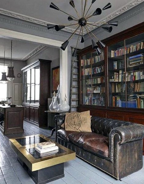 Living room with vintage leather sofa, old wooden bookshelf, and modern chandelier.