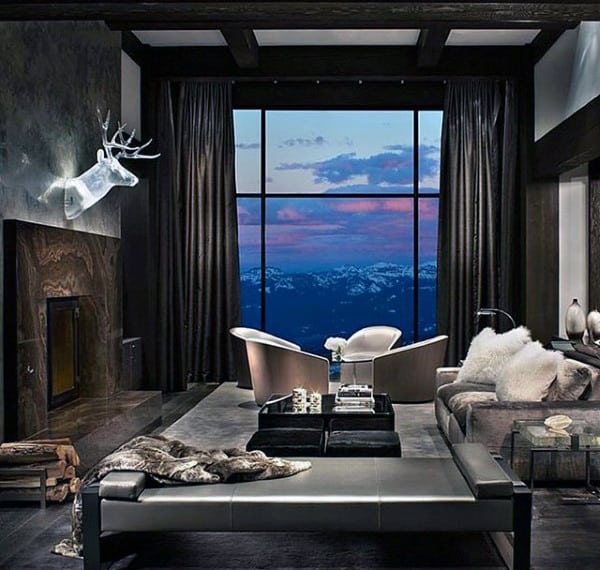 Masculine living room with floor-to-ceiling windows, leather furniture, and mountain view.