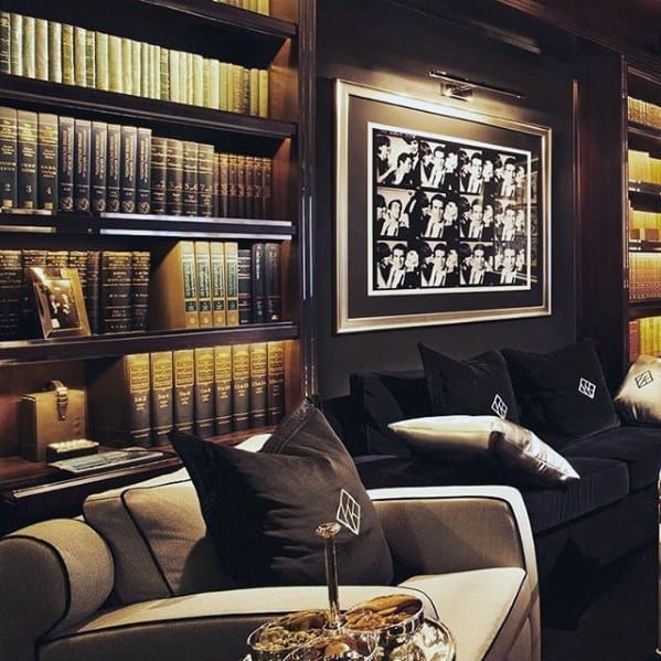 Luxurious man cave with leather-bound books, black-and-white photo, plush seating, and elegant decor