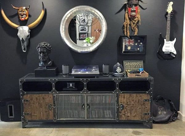 Industrial-style room with wall decor, guitar, mirror, and a metal-wooden console holding a record player