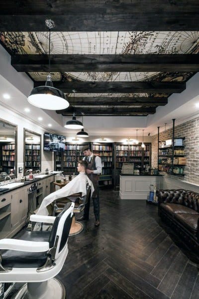 Barber shop with a library theme, map ceiling design, leather sofa, and dark wood flooring.