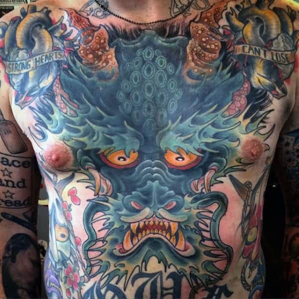 A man's chest tattoo featuring a colorful and detailed dragon face