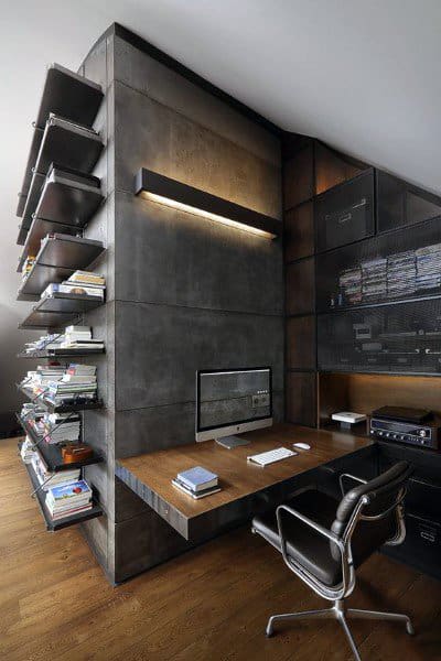 Industrial-style home office with black walls, wooden desk, shelves, and modern swivel chair.
