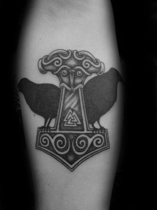 Blackwork tattoo of Huginn and Muninn flanking Mjölnir, with the Valknut symbol at the center of the hammer on the forearm.