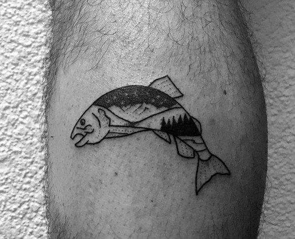 Minimalist black and grey salmon tattoo with a mountain and forest landscape inside its body, symbolizing nature and adventure in a small leg design.