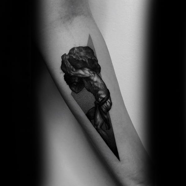 Minimalist blackwork Sisyphus tattoo on the forearm, showing the figure pushing a boulder within a sharp triangular frame.
