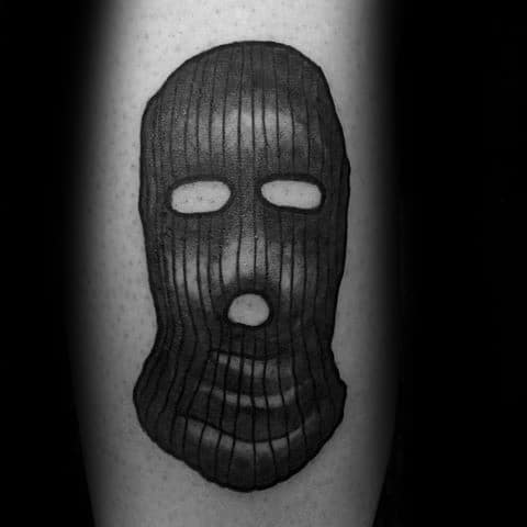 Tattoo of a dark, ribbed ski mask with eye and mouth cutouts, shaded to give a 3D, realistic texture.