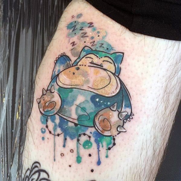 Watercolor-style Snorlax tattoo with dreamy splashes of blue, green, and gold, floating with Z’s above its head in sleep.