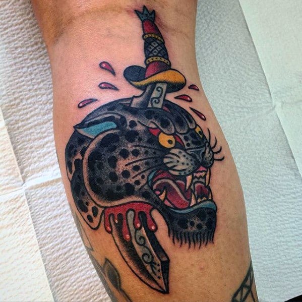 Bold traditional snow leopard tattoo with a dagger through its head, vivid colors, and dripping blood for a dramatic, old-school look.