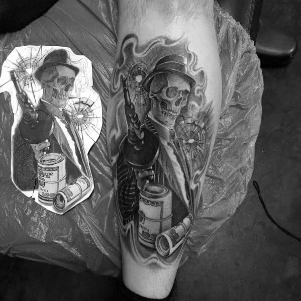 Black and grey gangster-themed tattoo featuring a skeleton in a suit holding a Tommy gun, with bullet holes, smoke effects, and stacks of cash.
