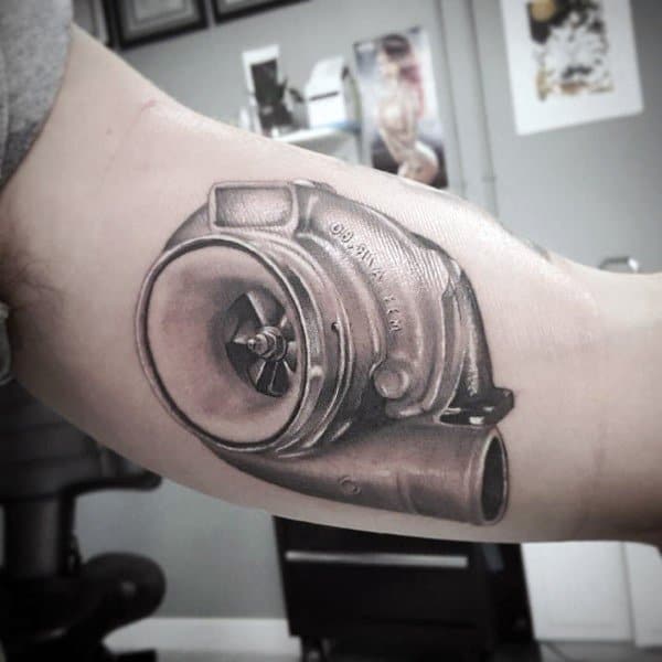 Realistic turbocharger tattoo on the inner bicep with fine shading and metallic detailing, symbolizing speed, power, and automotive passion.