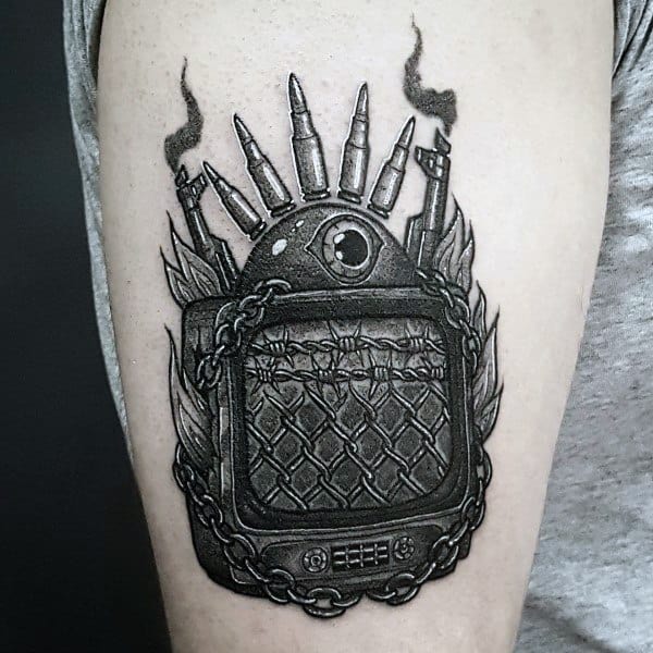 Black and grey tattoo of a vintage TV with a quilted screen, chained frame, an all-seeing eye, and bullets on top, emitting smoke in a bold design.