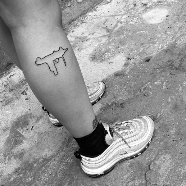 Minimalist Uzi tattoo on the lower leg with a simple black outline design, creating a sleek and understated look.