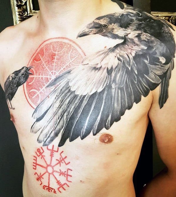 Chest tattoo featuring two ravens, a red compass-like symbol, and several runes on a man's chest