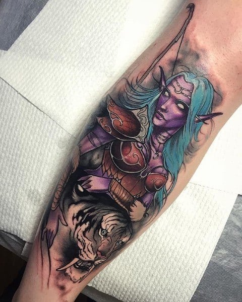 Colorful tattoo of a Night Elf from World of Warcraft, featuring purple skin, glowing eyes, ornate armor, and a fierce white tiger companion, inked on the forearm.