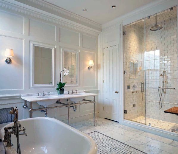 Classic master bathroom featuring elegant crown molding, freestanding tub, double sink, and a glass-enclosed shower