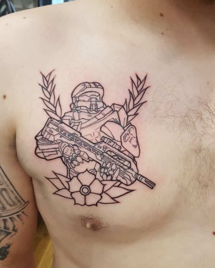 Line-art Halo tattoo of Master Chief holding a rifle, framed by laurel leaves and a geometric flower, inked on the chest.