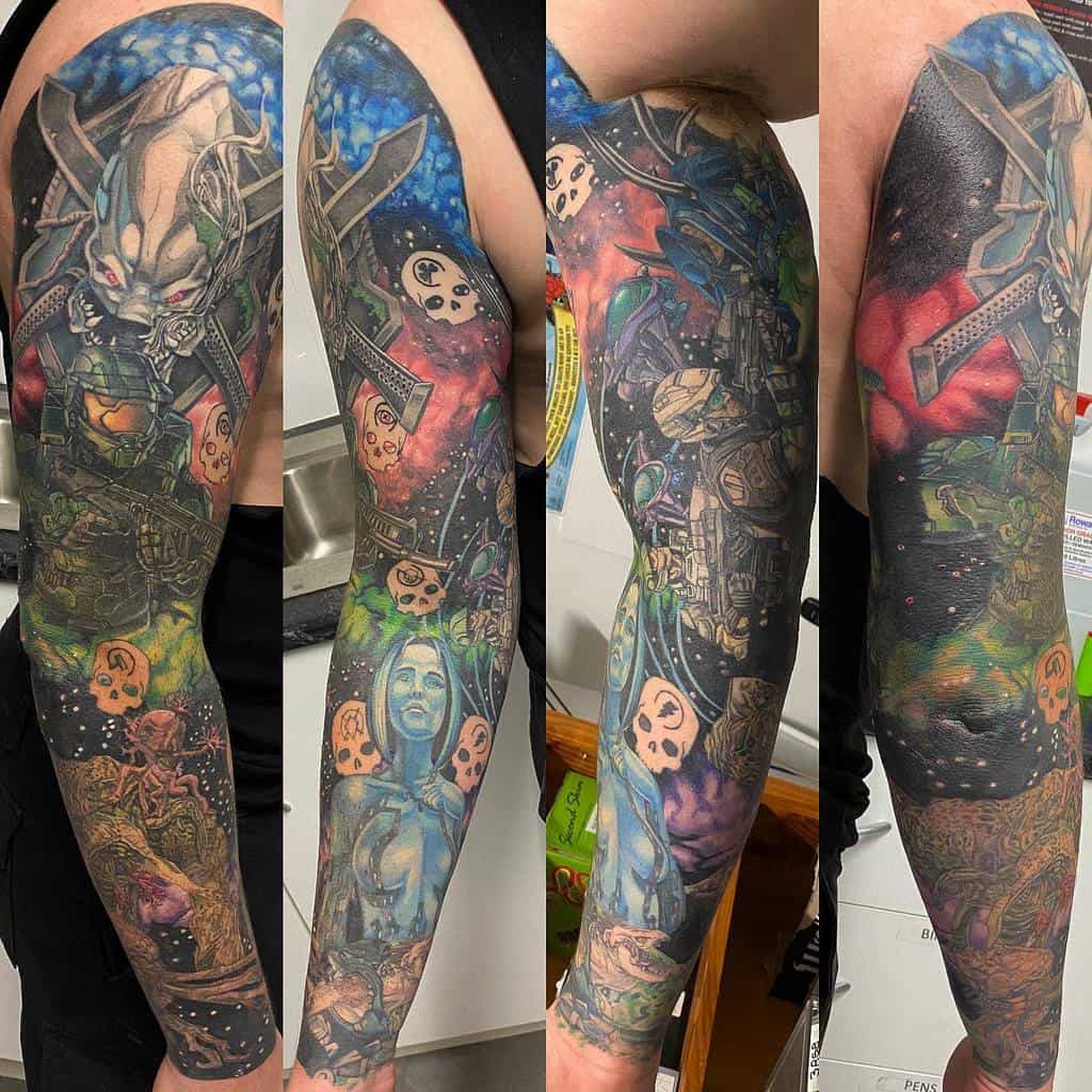 Full-sleeve Halo tattoo featuring Master Chief, Cortana, an Elite, and a cosmic battlefield with vibrant colors and detailed shading.