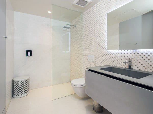 Minimalist bathroom with a glass shower, modern vanity, wall mirror, and sleek white textured walls